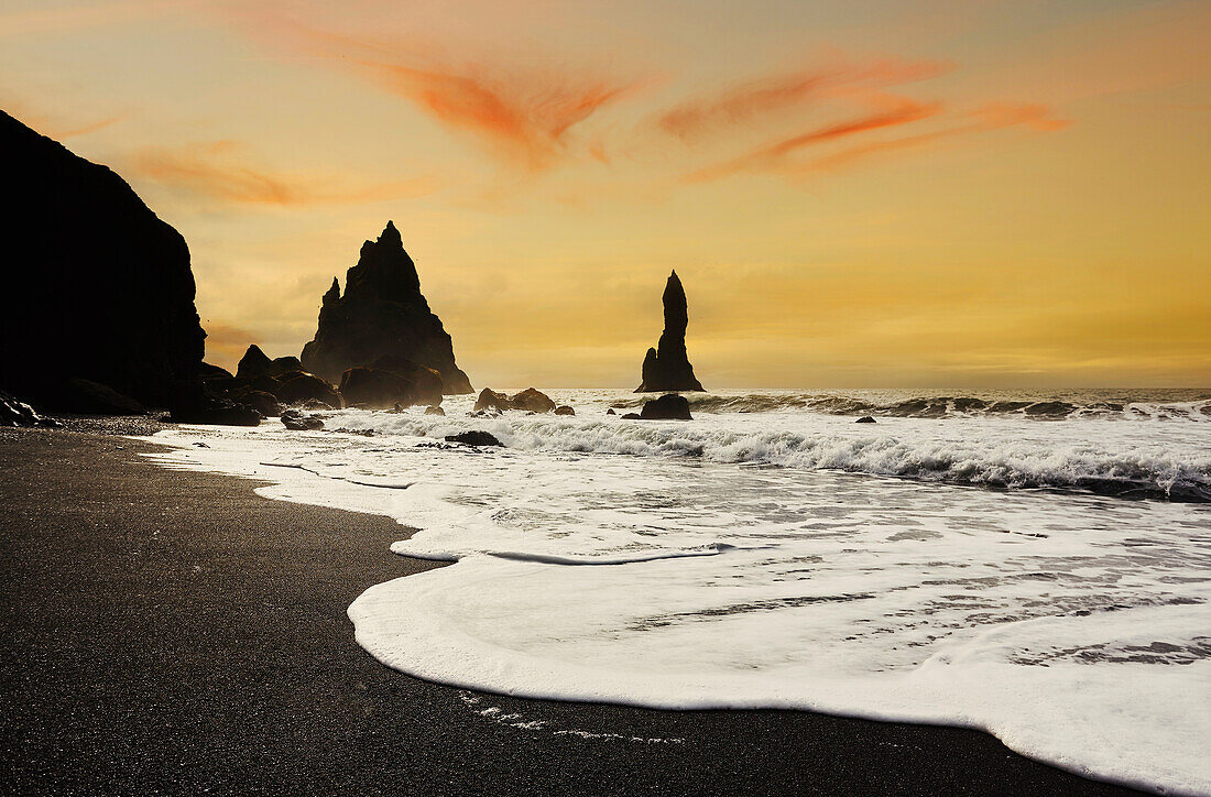 Silhouettierte Felsen entlang der Küste bei Reynisfjara, nahe Vik, Südküste Islands, Polarregionen