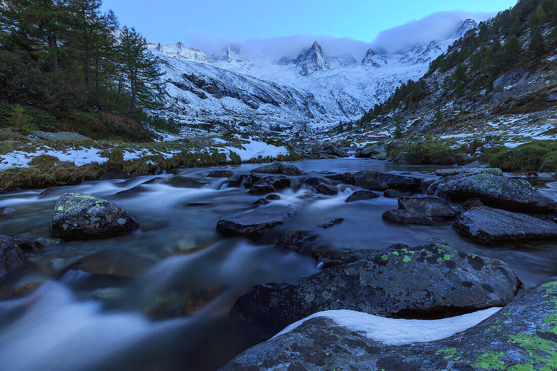 Wildbach in der Abenddämmerung vor verschneiten Bergen, Valmasino, Valtellina, Lombardei, Italien, Europa