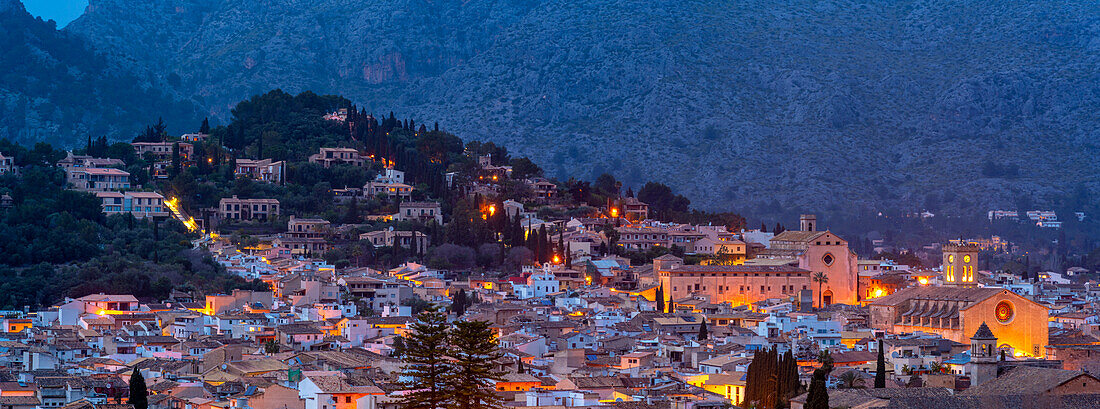 Blick auf Kirchen und Dächer von Pollenca mit Berg im Hintergrund in der Abenddämmerung, Pollenca, Mallorca, Balearische Inseln, Spanien, Mittelmeer, Europa