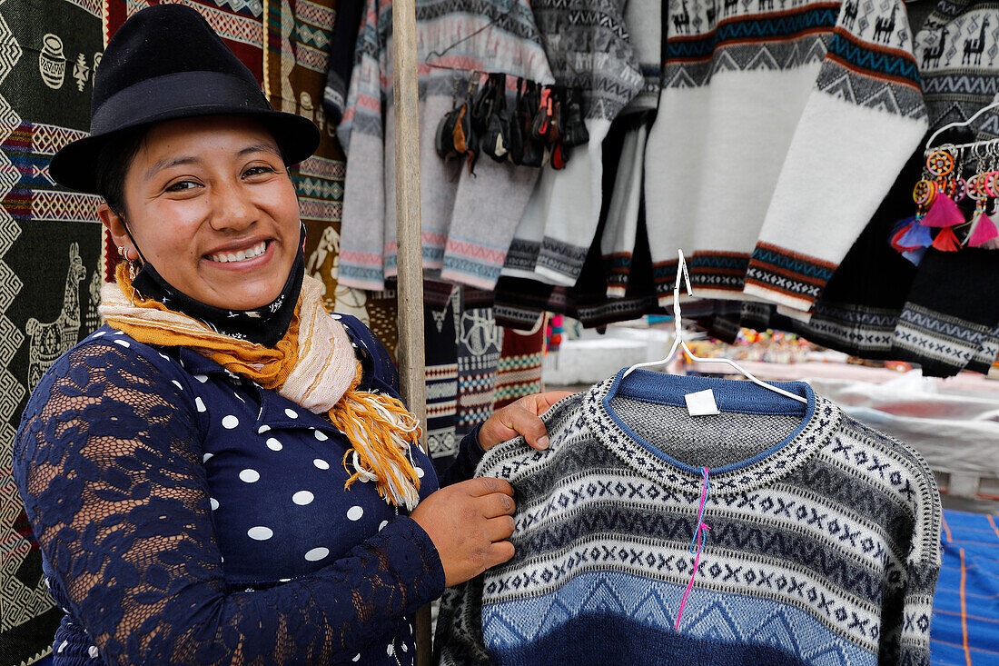 Standinhaber, der Strickwaren auf dem Markt von Otavalo verkauft, Otavalo, Ecuador, Südamerika
