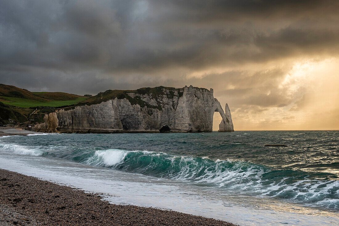 Sonnenuntergang vom Strand von Etretat, über das Meer, die Klippen und den natürlichen Bogen, Etretat, Normandie, Frankreich, Europa