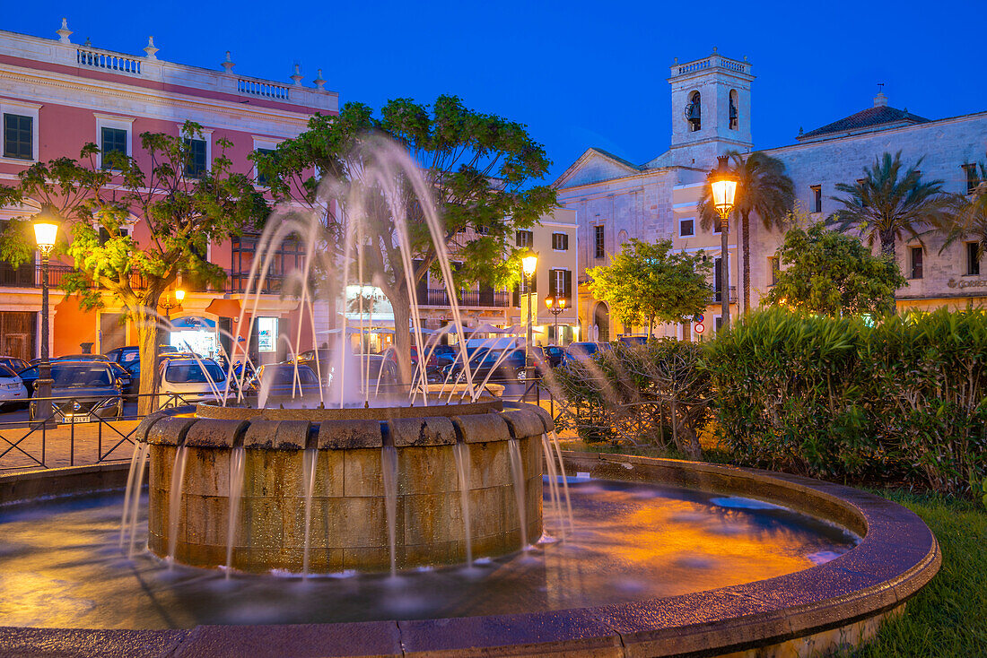 Blick auf den Brunnen und den Glockenturm der Kirche am Placa des Born in der Abenddämmerung, Ciutadella, Menorca, Balearische Inseln, Spanien, Mittelmeer, Europa