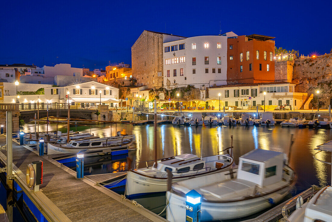 Blick auf Boote im Yachthafen mit Blick auf weiß getünchte Gebäude in der Abenddämmerung, Ciutadella, Menorca, Balearen, Spanien, Mittelmeer, Europa