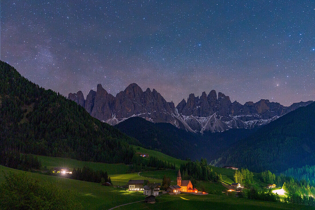 Das märchenhafte Bergdorf Santa Magdalena und die Geislergruppe unter dem nächtlichen Sternenhimmel, Funes-Tal, Dolomiten, Südtirol, Italien, Europa