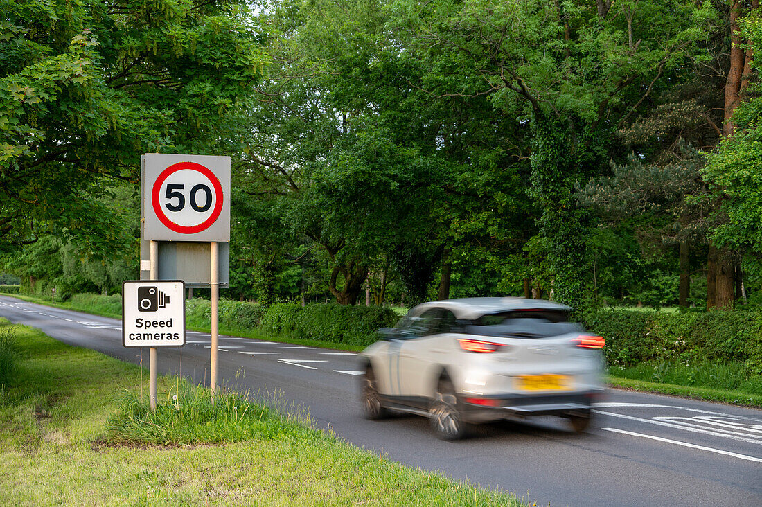 Vehicle travelling towards 50mph and speed camera signs on a Cheshire road, Cheshire, England, United Kingdom, Europe