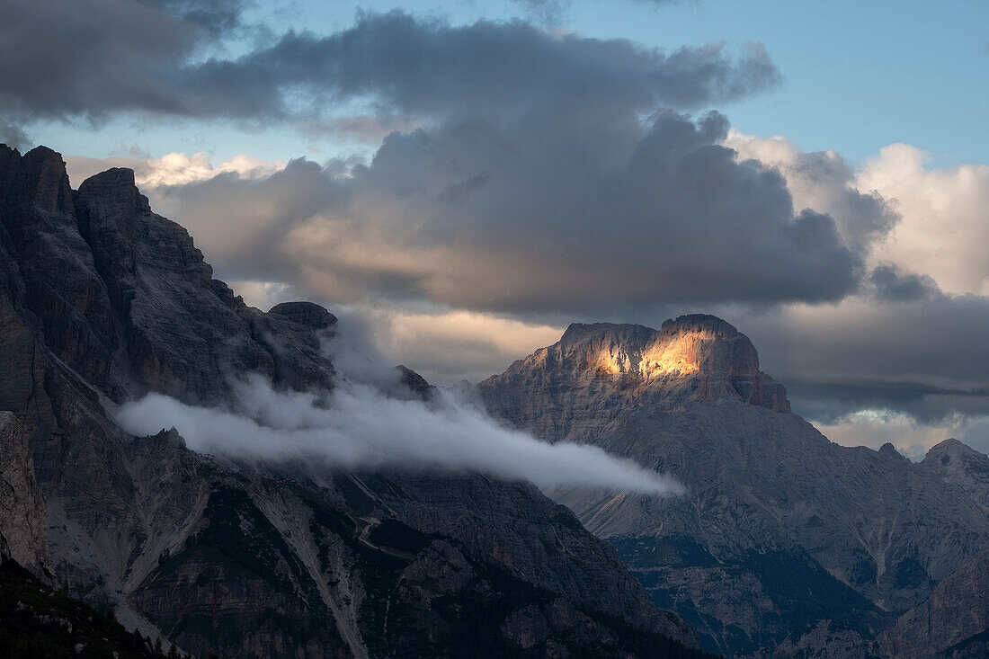 Sunset with clouds on Croda Rossa d'Ampezzo in the Dolomites with a single beam of light on the rock, Dolomites, Italy, Europe
