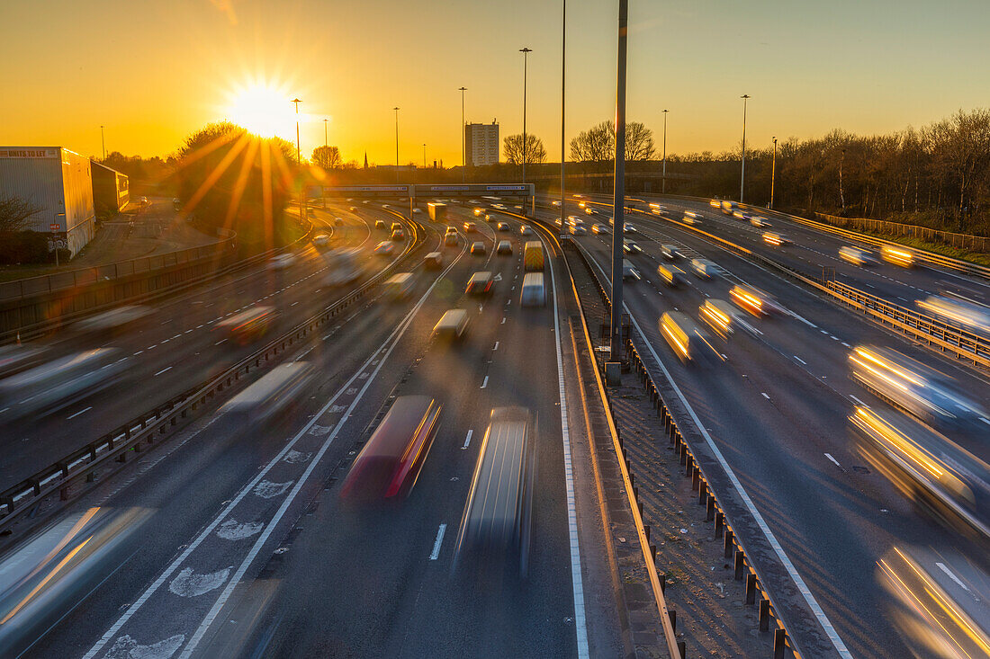 Sonnenuntergang über dem Verkehr auf der Autobahn M8, Glasgow, Schottland, Vereinigtes Königreich, Europa