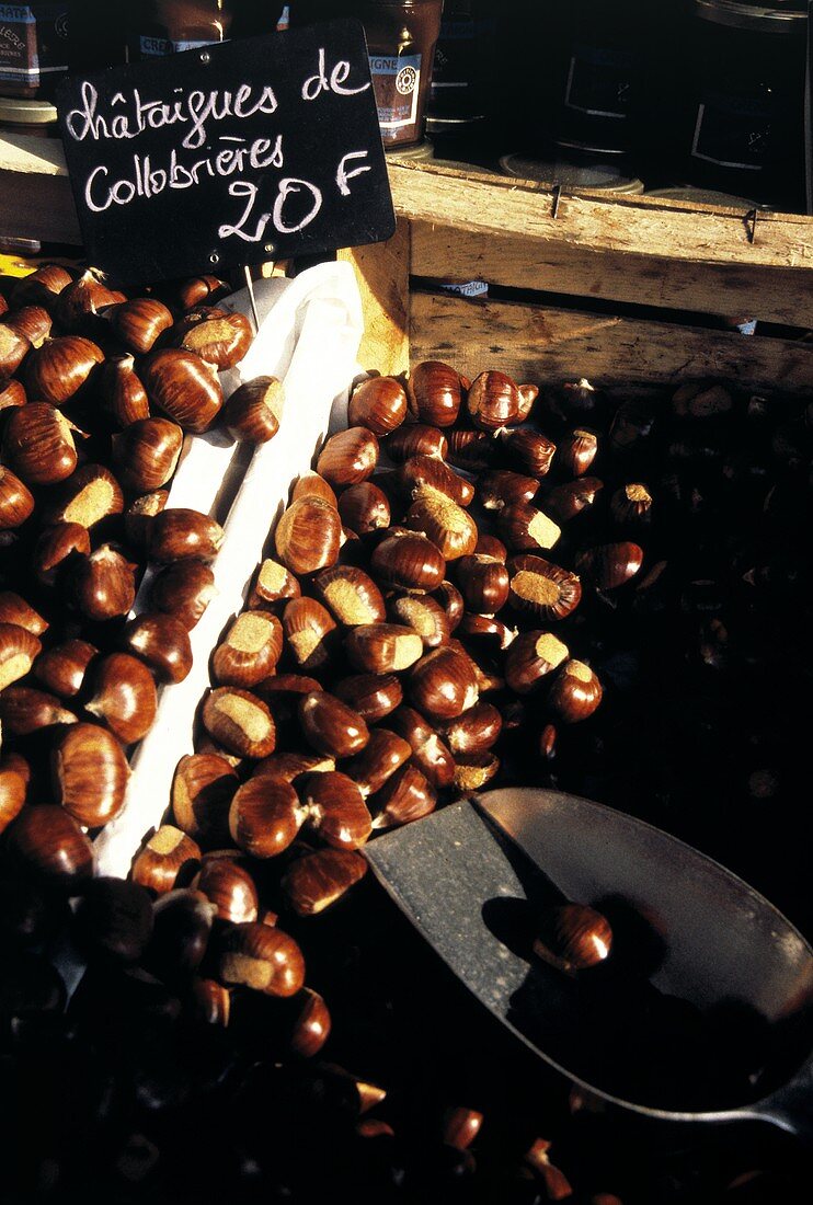 A Man Selling Chestnuts at an Outdoor Market
