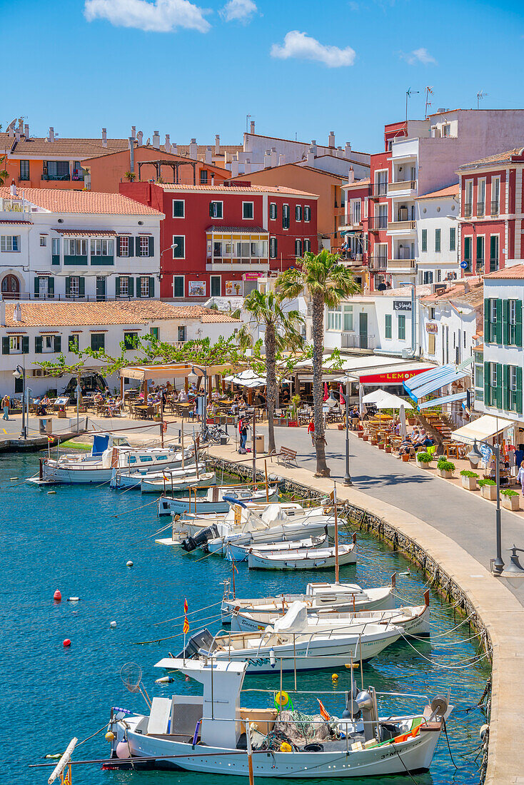 View of colourful cafes, restaurants and boats in harbour against blue sky, Cales Fonts, Menorca, Balearic Islands, Spain, Mediterranean, Europe