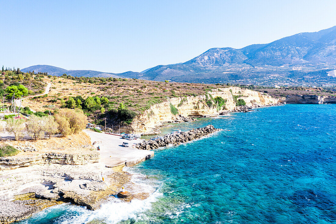 Waves of the turquoise sea crashing on rocks at the small harbour of Pessada, aerial view, Kefalonia, Ionian Islands, Greek Islands, Greece, Europe