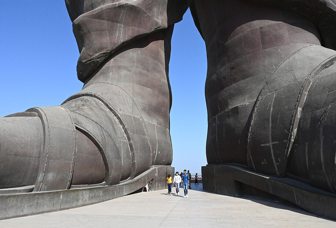 Besucher zwischen den Füßen der Statue der Einheit, der mit 182 m höchsten Statue der Welt von Vallabhbhai Patel, Kevadia, Gujarat, Indien, Asien