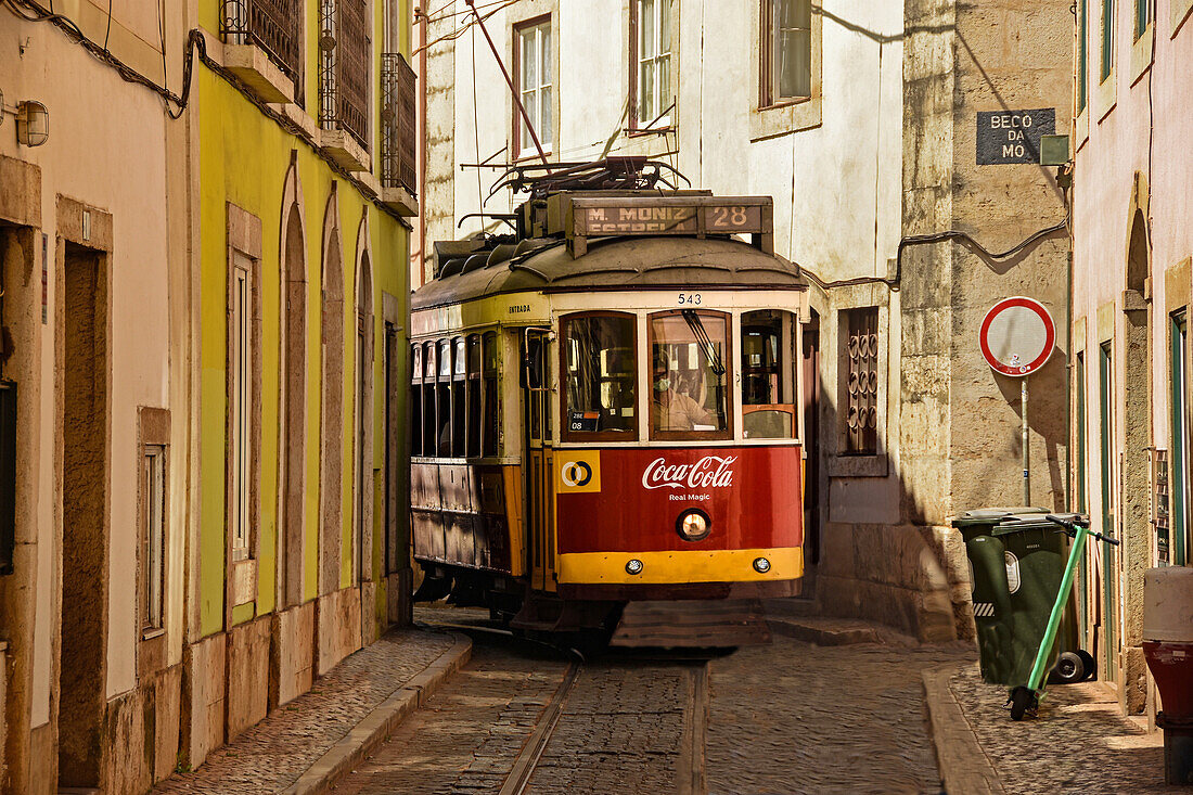 Tram on route 28 through the narrow streets of Alfama old town, Lisbon, Portugal, Europe