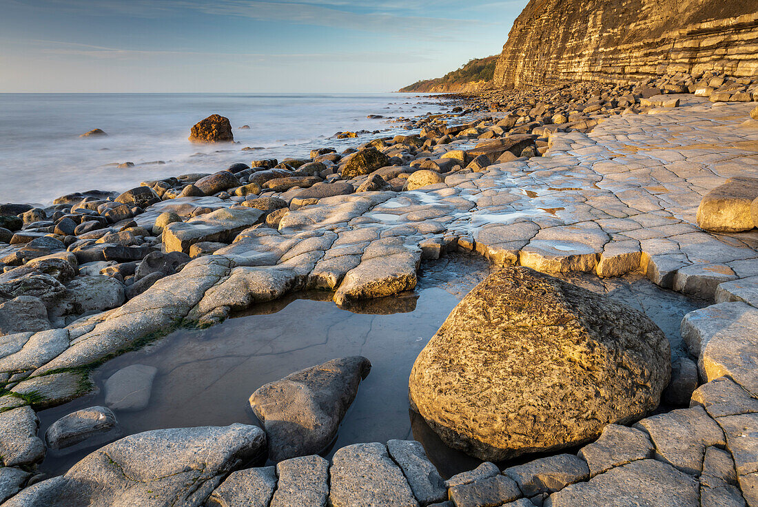 Das morgendliche Sonnenlicht beleuchtet das Ammonitenpflaster bei Lyme Regis, Dorset, England, Vereinigtes Königreich, Europa