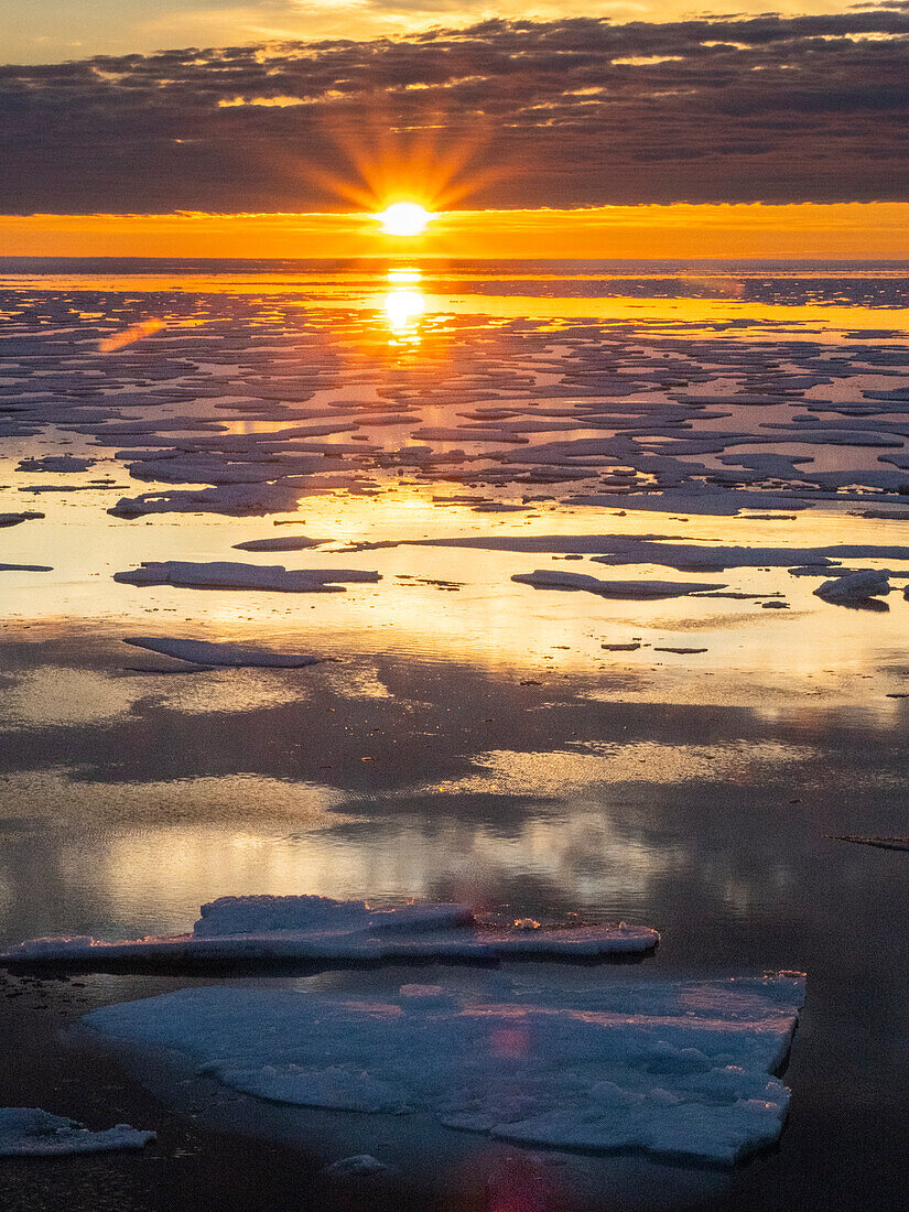 Sunset over melt water pools in the heavy pack ice in McClintock Channel, Northwest Passage, Nunavut, Canada, North America