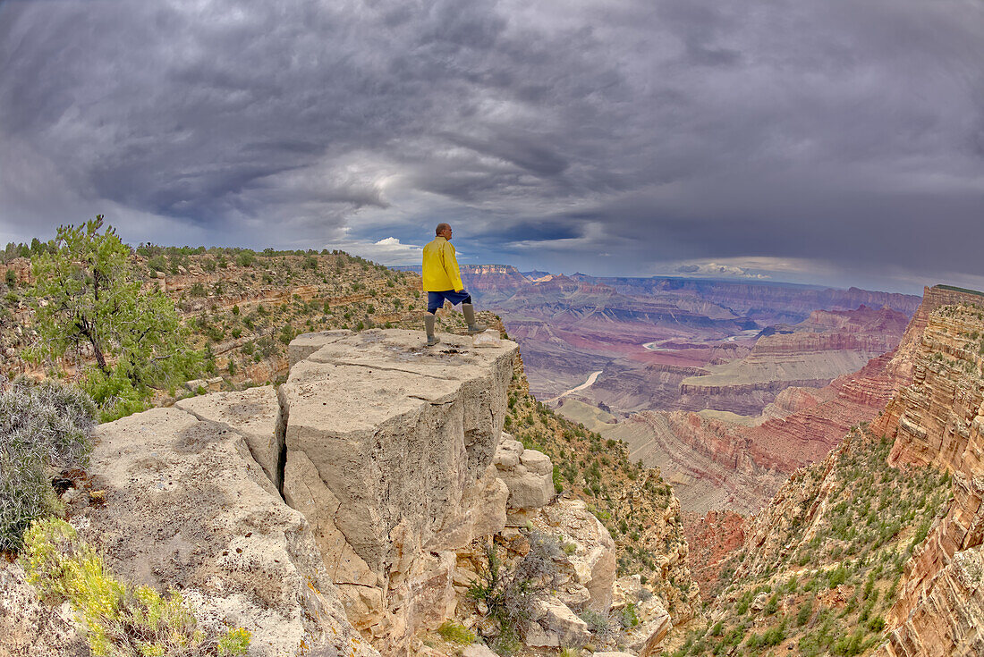 Ein Wanderer steht an einem stürmischen Tag auf einer Klippe zwischen Zuni und Papago Points am Grand Canyon, Grand Canyon National Park, UNESCO-Weltnaturerbe, Arizona, Vereinigte Staaten von Amerika, Nordamerika