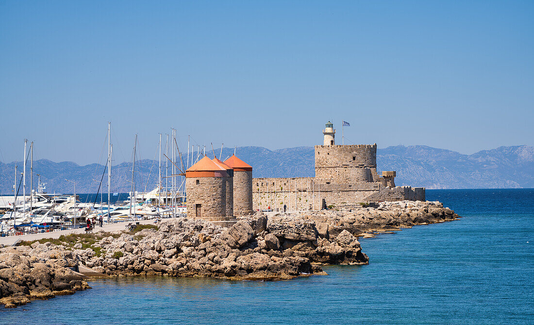 The Saint Nicholas Fortress and windmills at Mandraki Harbor, Rhodes, Dodecanese, Greek Islands, Greece, Europe