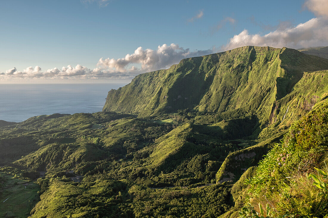 View at sunset of the mountains on the west side of Flores with lush green vegetation and some clouds, Flores Island, The Azores, Portugal, Atlantic