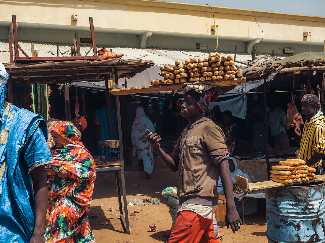Ein Mann trägt Brot auf dem Markt eines Dorfes in der Nähe von Ayoun El Atrous, Hodh El Gharbi, Mauretanien, Wüste Sahara, Westafrika, Afrika