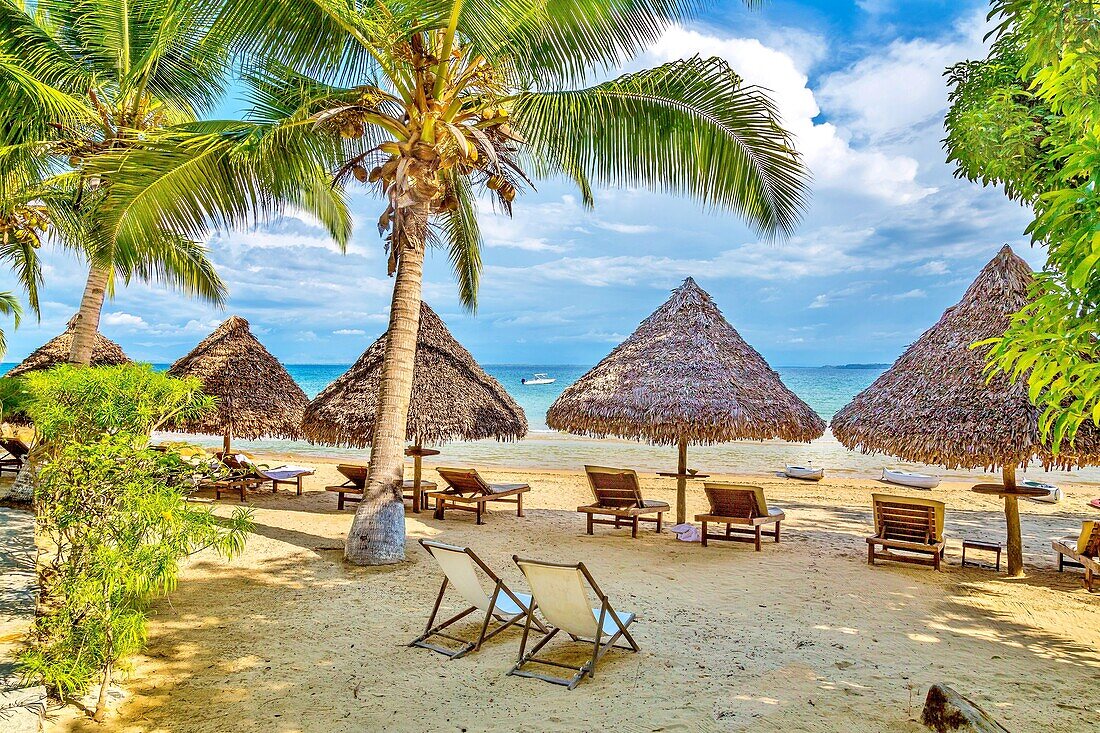 Sonnenschirme und Liegestühle am Meer auf der Insel Nosy Be, Nosy Komba, Nordwest-Madagaskar, Indischer Ozean, Afrika