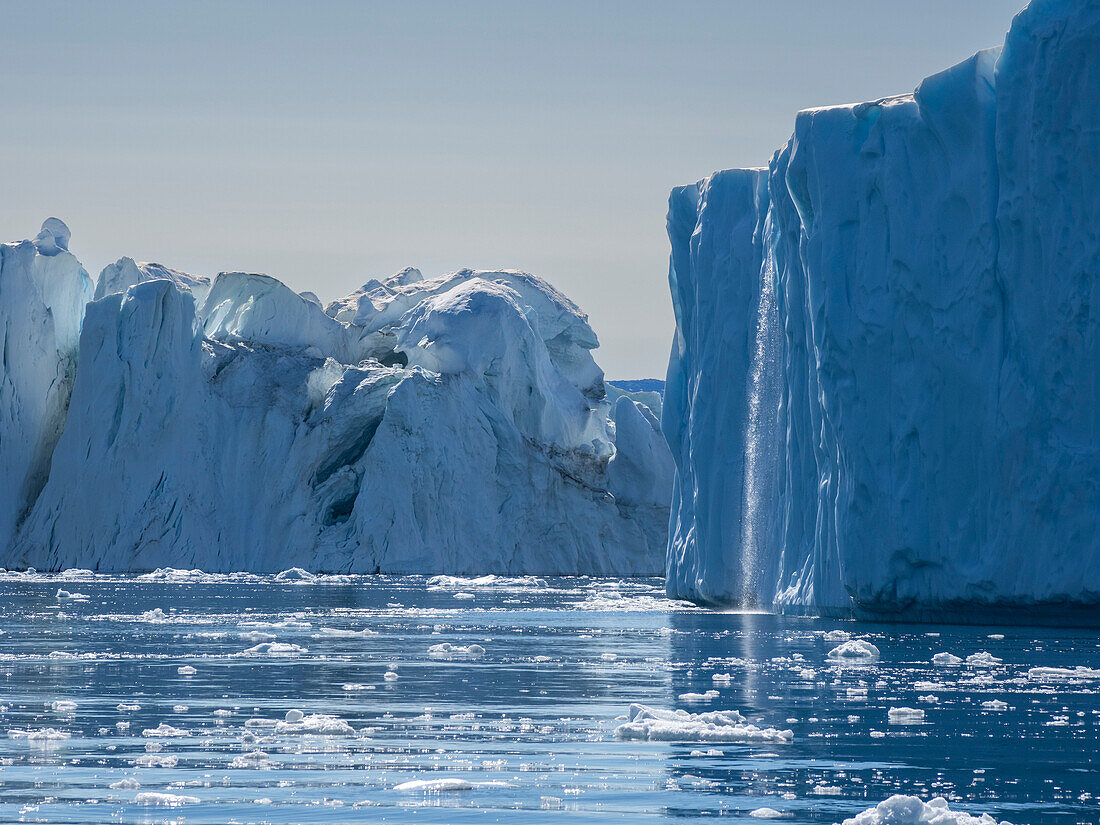 A waterfall from melting icebergs from the Ilulissat Icefjord just outside the city of Ilulissat, Greenland, Denmark, Polar Regions