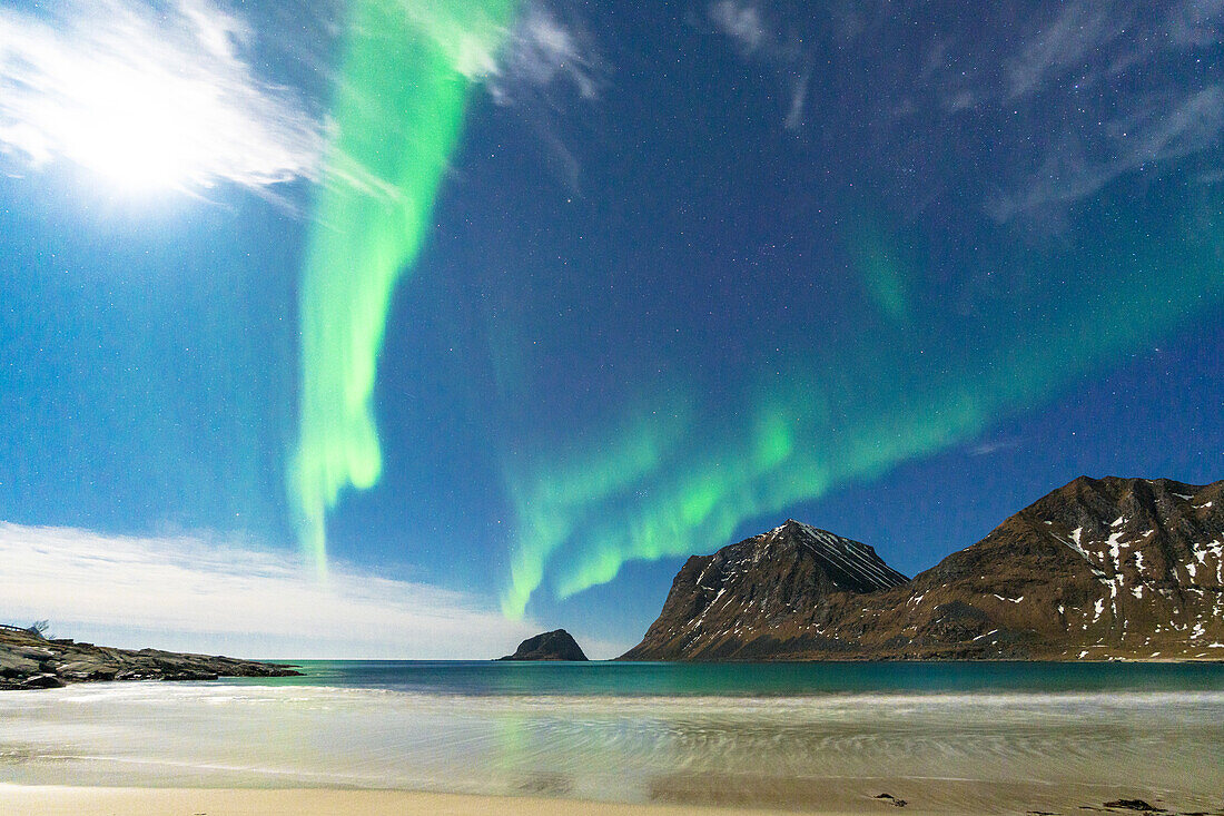Waves of the icy sea lit by moon and green lights of Aurora Borealis (Northern Lights), Haukland beach, Leknes, Lofoten Islands, Norway, Scandinavia, Europe