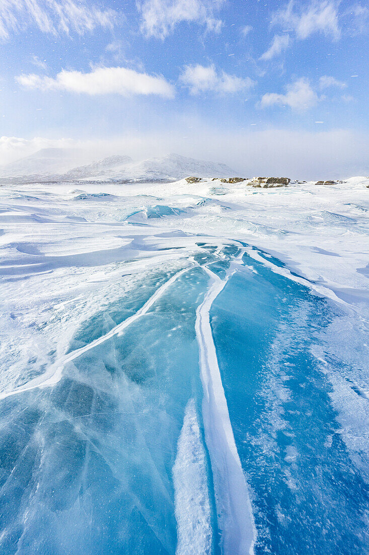 Geriffeltes transparentes Eis, das einen See in der Schneelandschaft bedeckt, Stora Sjofallet, Norrbotten County, Lappland, Schweden, Skandinavien, Europa