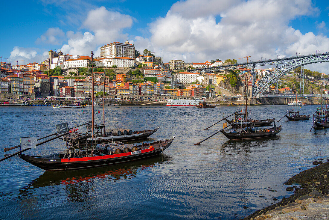 Blick auf die Brücke Dom Luis I über den Fluss Douro und die Rabelo-Boote, ausgerichtet auf bunte Gebäude, UNESCO-Welterbe, Porto, Norte, Portugal, Europa