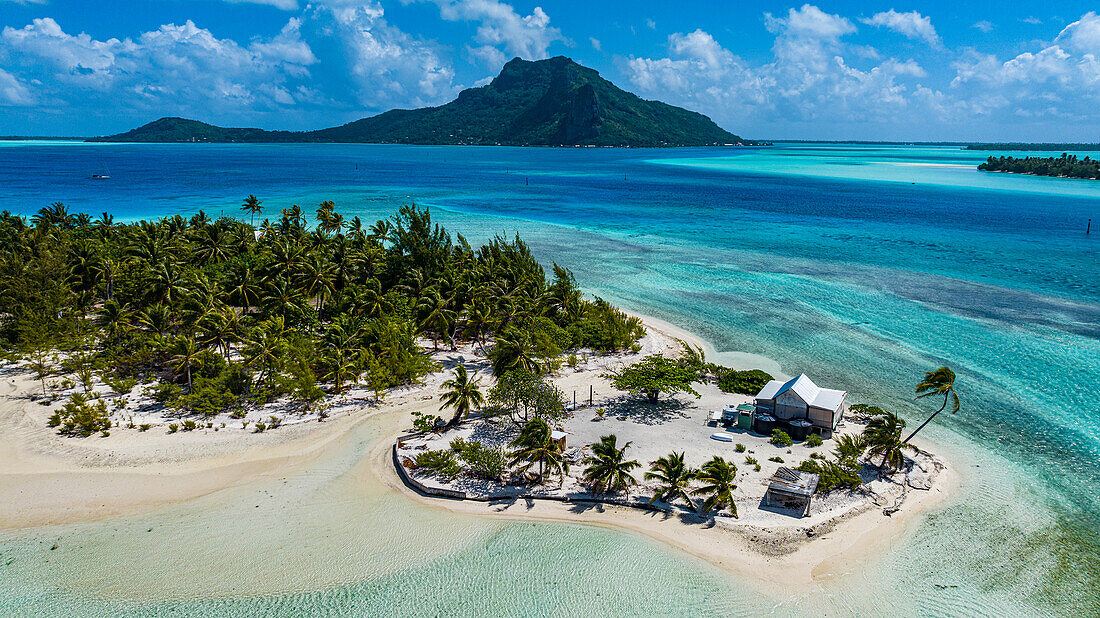 Aerial of a little islet with a white sand beach and the lagoon of Maupiti, Society Islands, French Polynesia, South Pacific, Pacific