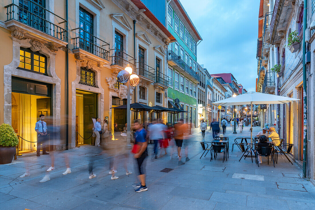 Blick auf eine belebte Straße mit Cafés und Bars in der Altstadt von Porto in der Abenddämmerung, Porto, Norte, Portugal, Europa