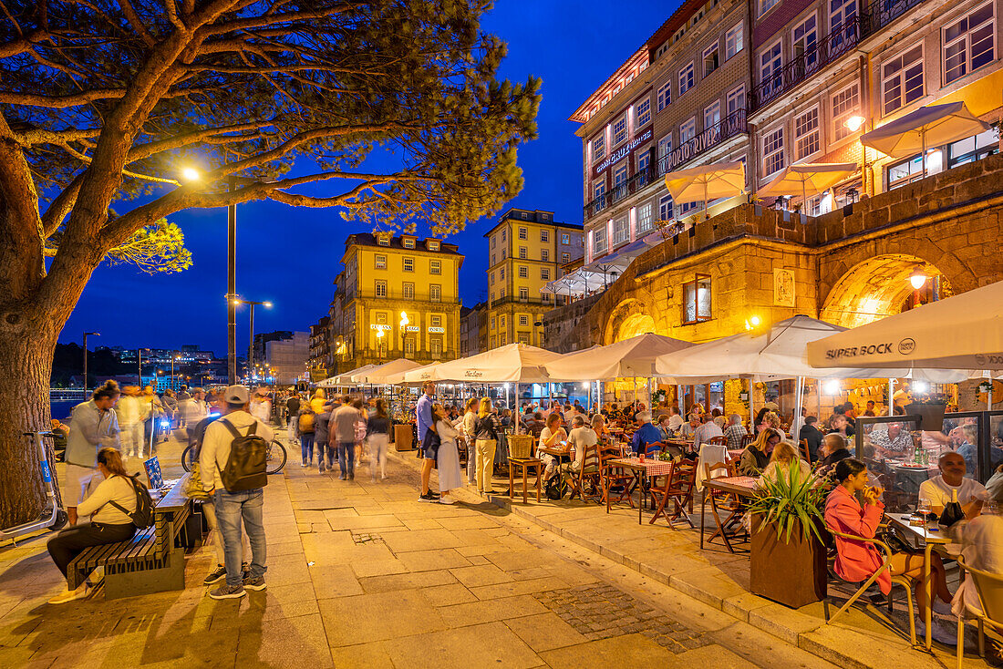 View of bars and restaurants at waterfront of Douro River at dusk, Porto, Norte, Portugal, Europe