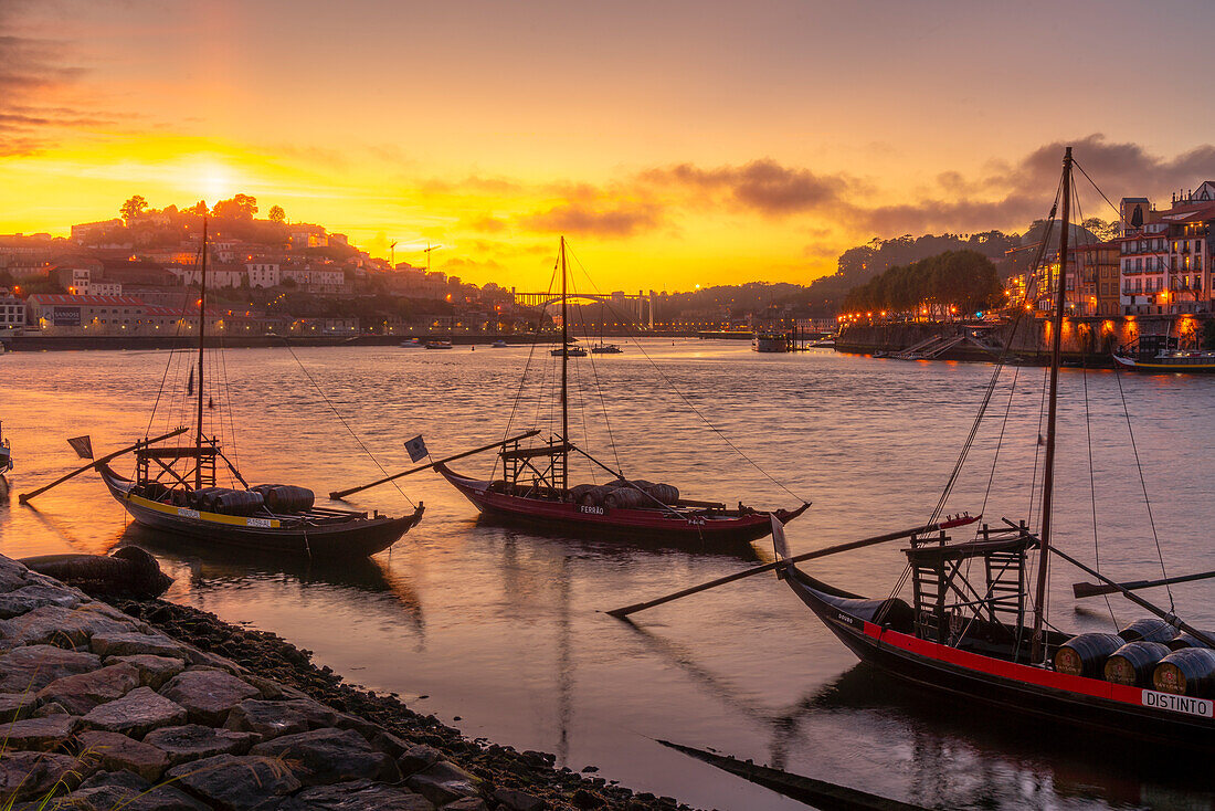 Blick auf den Douro-Fluss und die Rabelo-Boote mit den bunten Gebäuden bei Sonnenuntergang, Porto, Norte, Portugal, Europa
