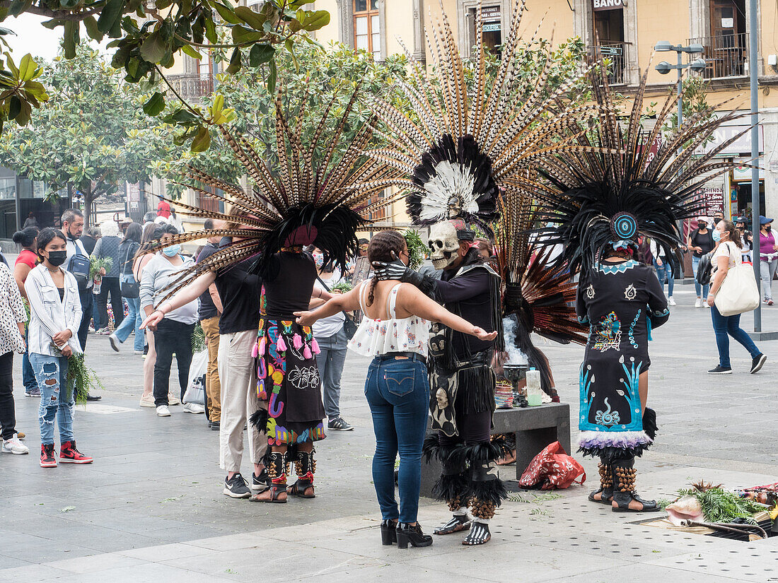 Menschen stehen Schlange, um traditionelle Zeremonien von indigenen Priestern in modernen Versionen der aztekischen Zeremonialkleidung zu empfangen, Mexiko-Stadt, Mexiko, Nordamerika