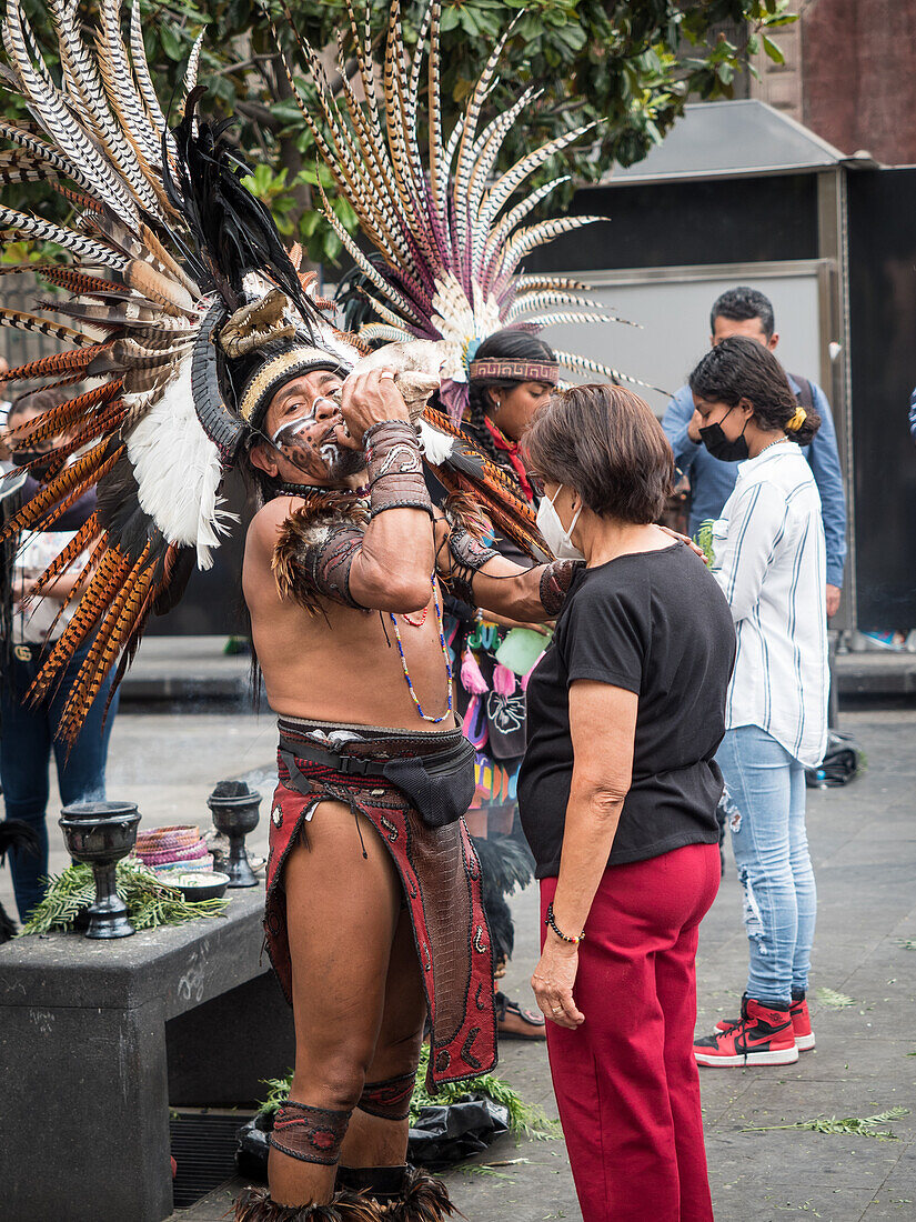 In der Altstadt stehen viele Menschen Schlange, um Zeremonien von indigenen Priestern in modernen Versionen aztekischer Zeremonialkleidung zu empfangen, Mexiko-Stadt, Mexiko, Nordamerika