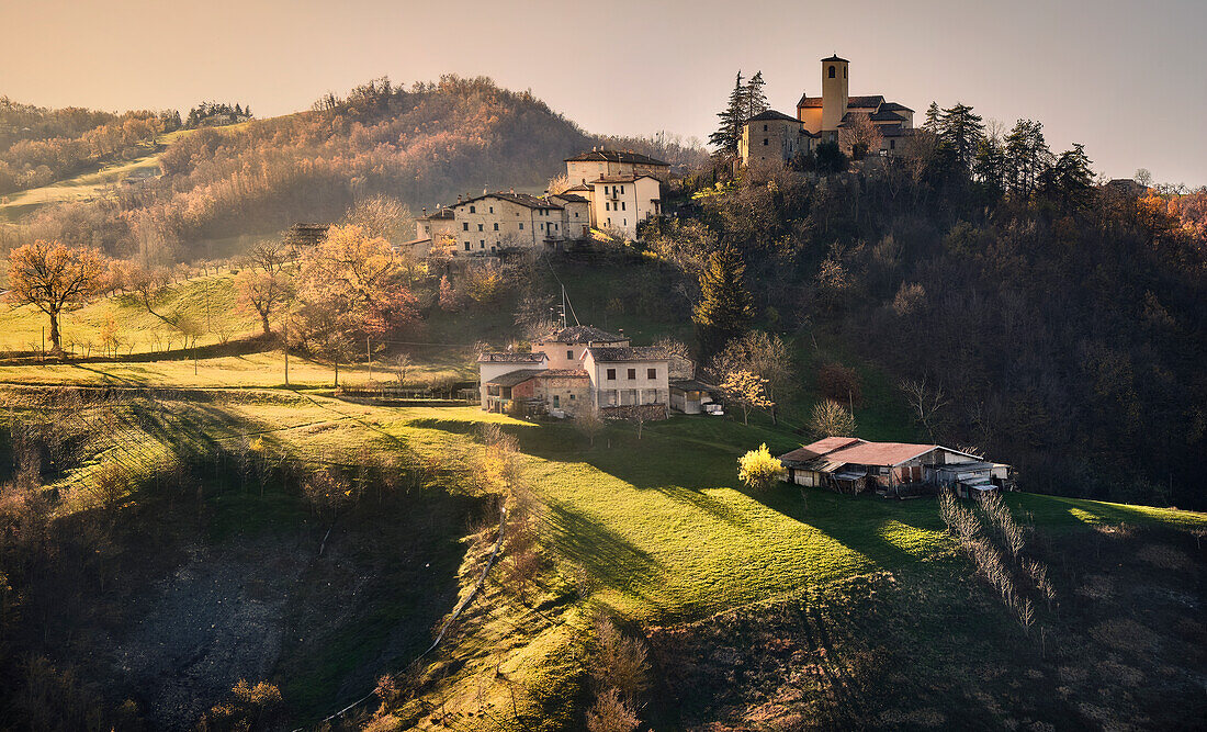 Ein Sonnenuntergang über dem kleinen Dorf Montecorone im Herbst, Emilia Romagna, Italien, Europa