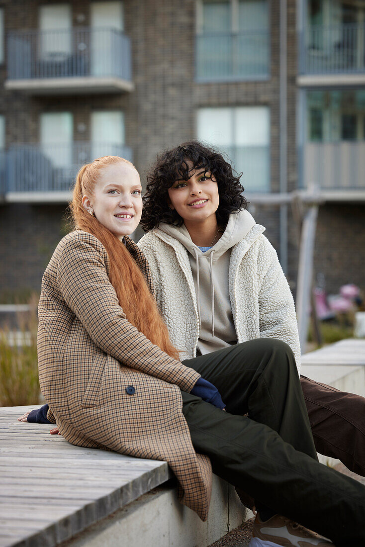 Young female friends sitting outdoors