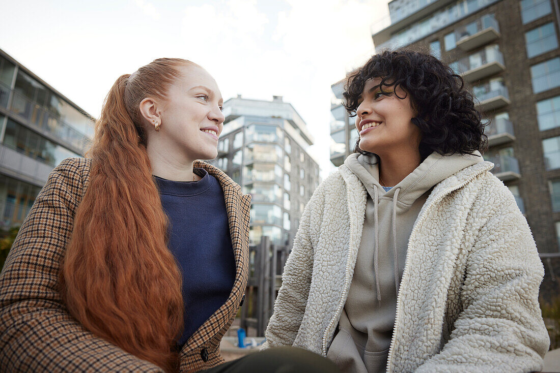 Young female friends talking outdoors