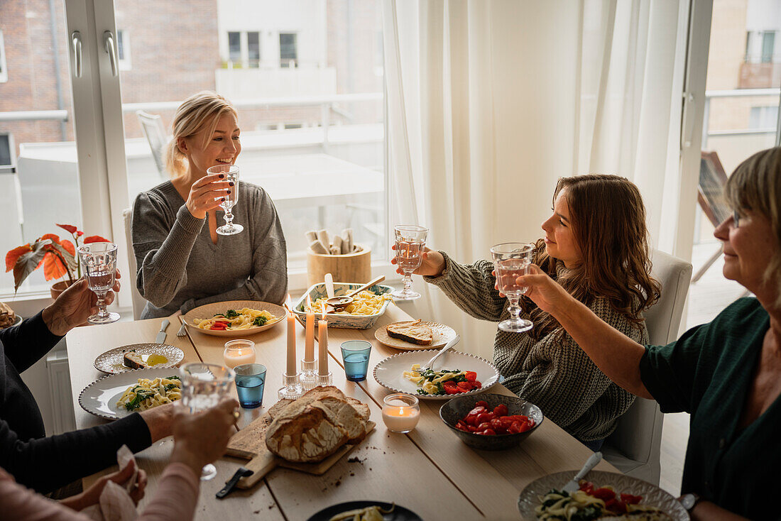 Familie stößt beim Abendessen an