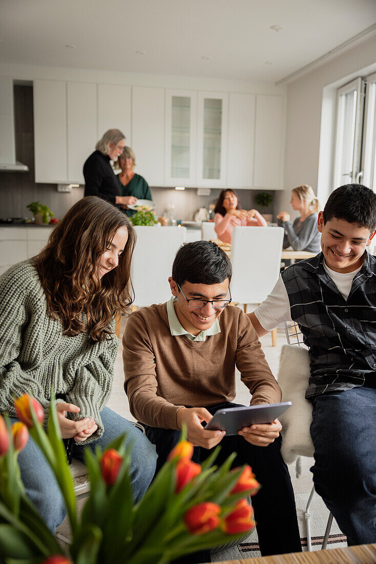 Siblings using digital tablet at home