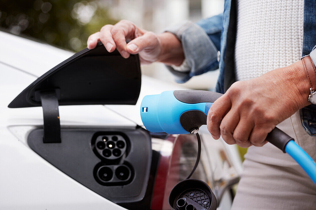 Woman charging electric car