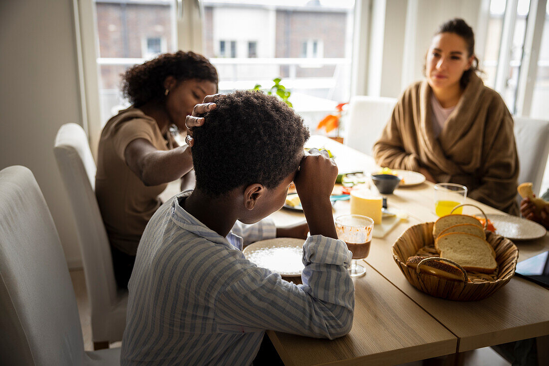 Mothers and sons eating breakfast