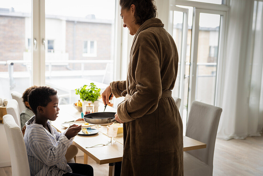 Mother serving breakfast for sons