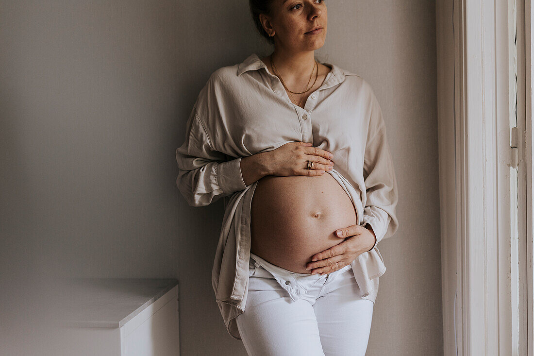 Pregnant woman holding hands on belly