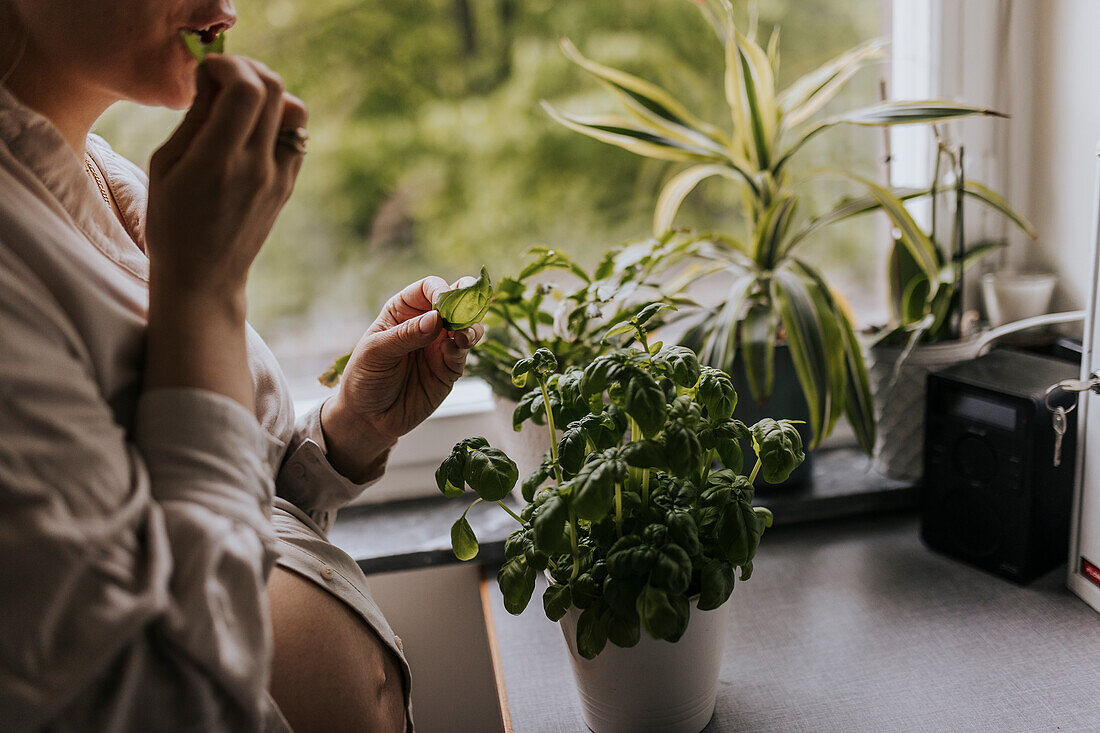 Woman eating fresh basil