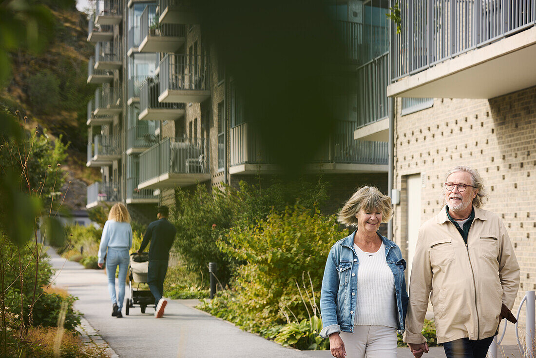 Young and senior couple walking in residential area