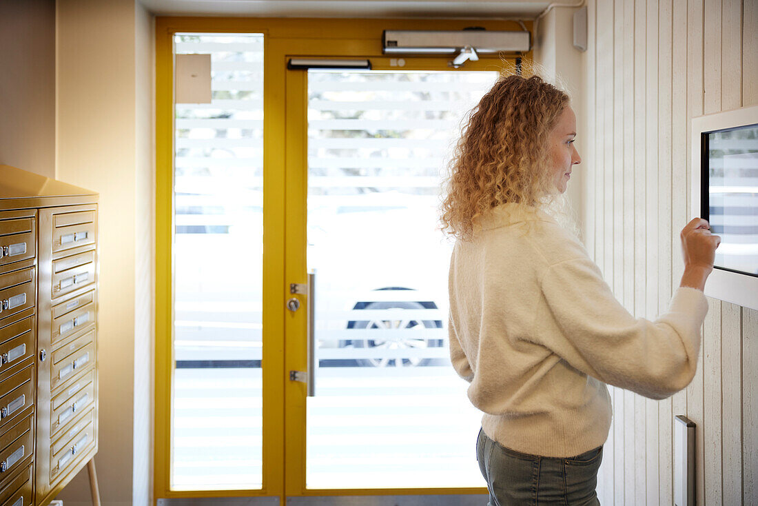 Woman entering block of flats