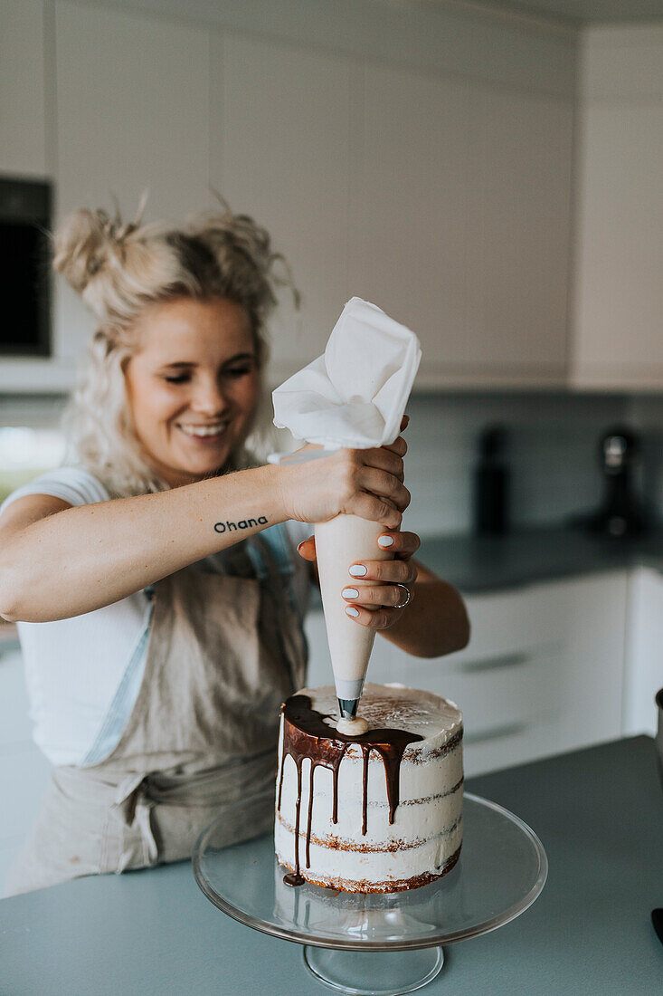 Frau in der Küche beim Verzieren von Kuchen