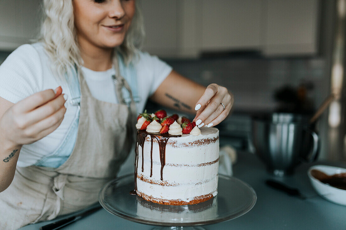 Woman in kitchen decorating cake