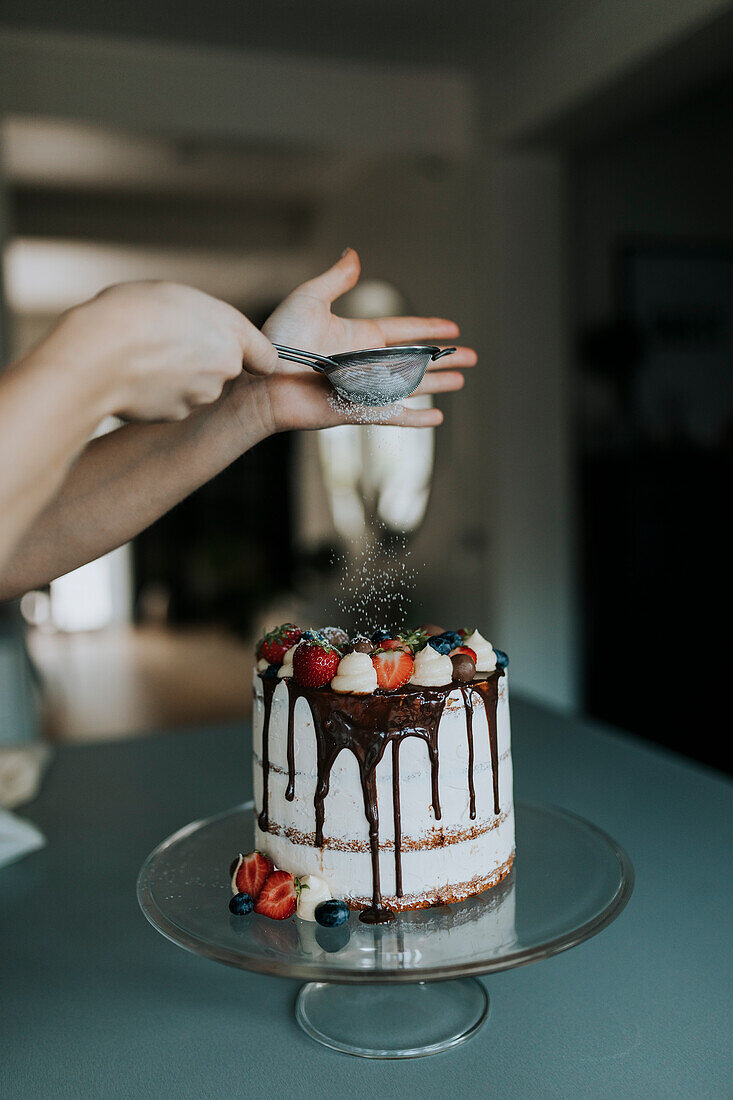 Woman in kitchen decorating cake