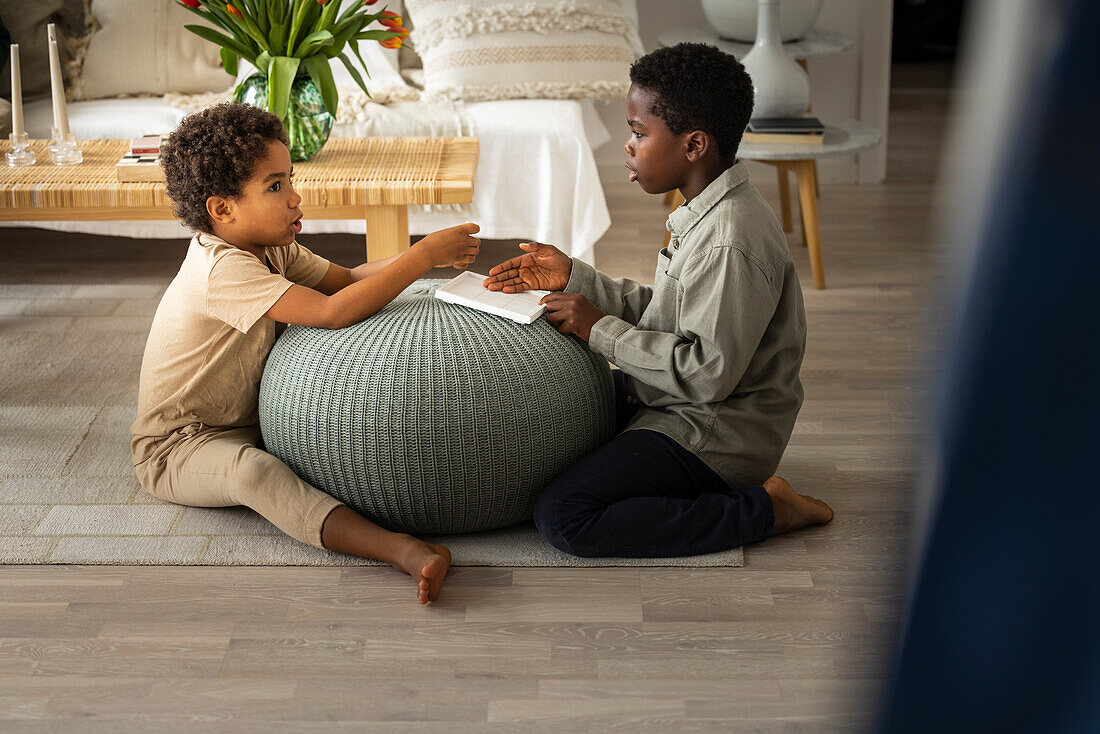 Boys sitting on floor and playing at home