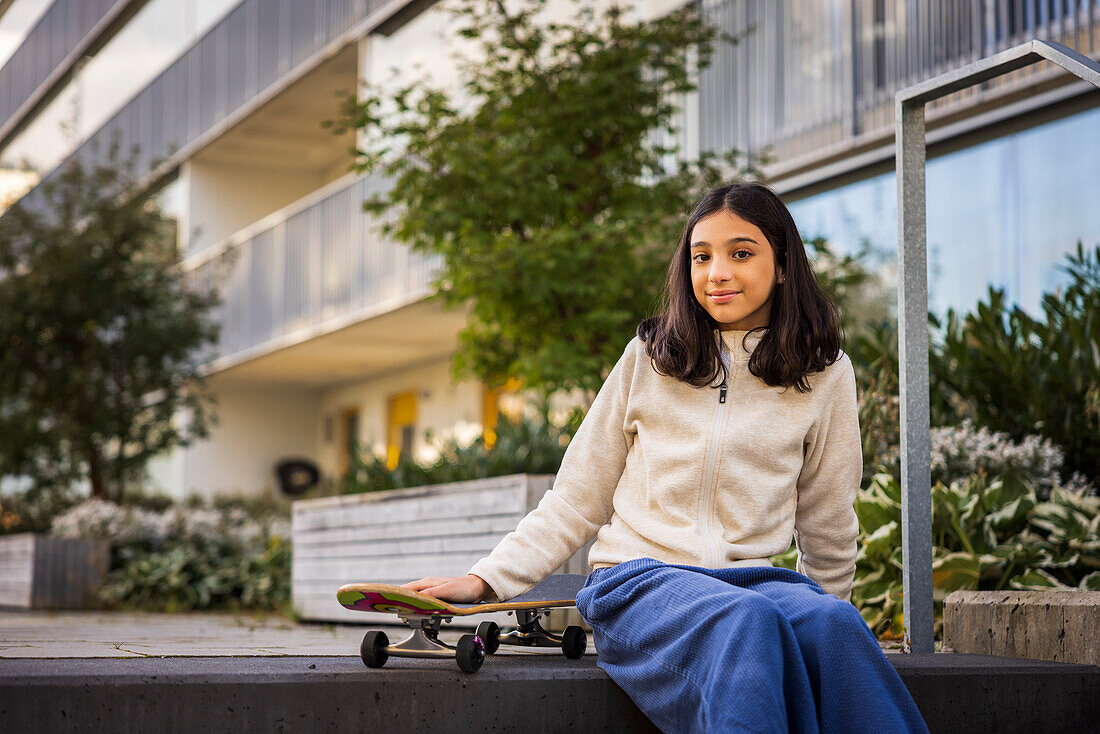 Portrait of girl holding skateboard